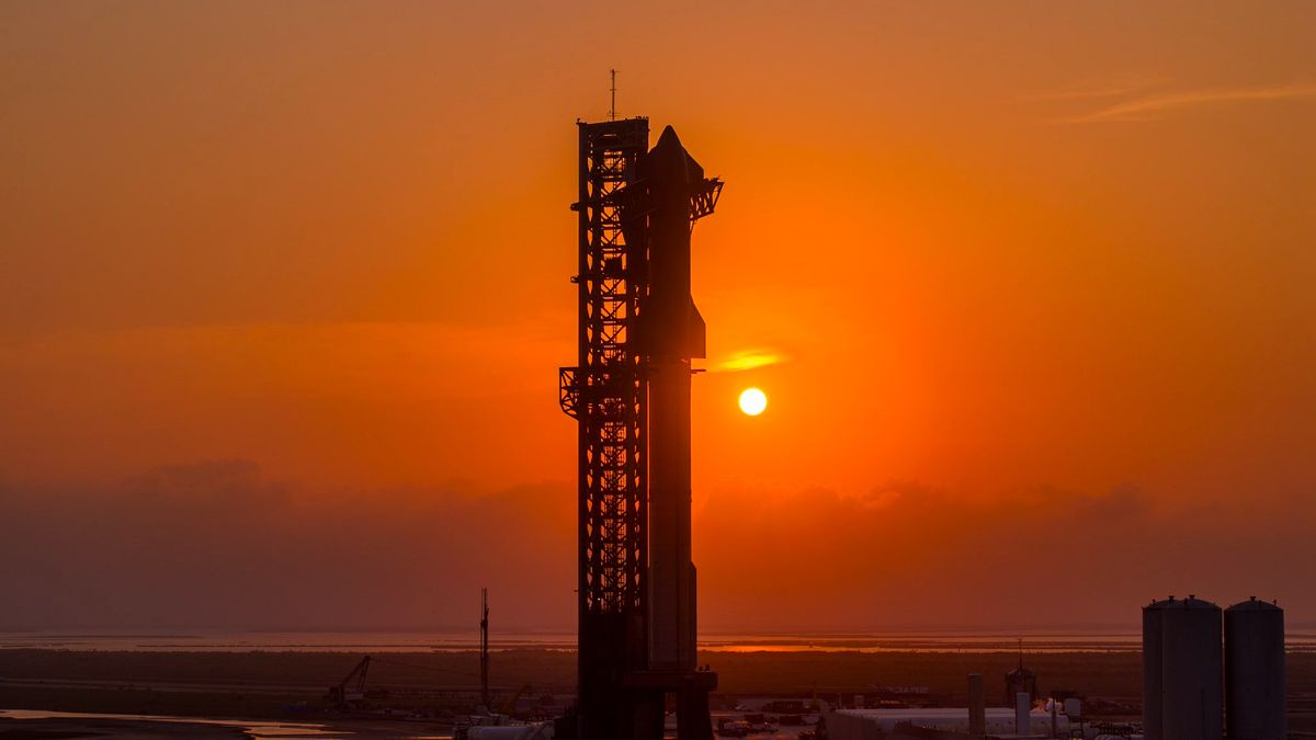 a giant rocket stands on a launch pad with the setting sun in the background