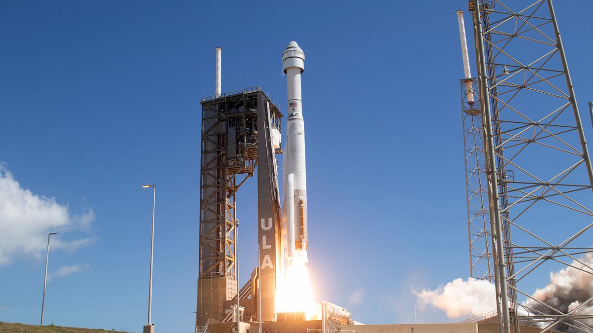 a white rocket launches into a blue sky