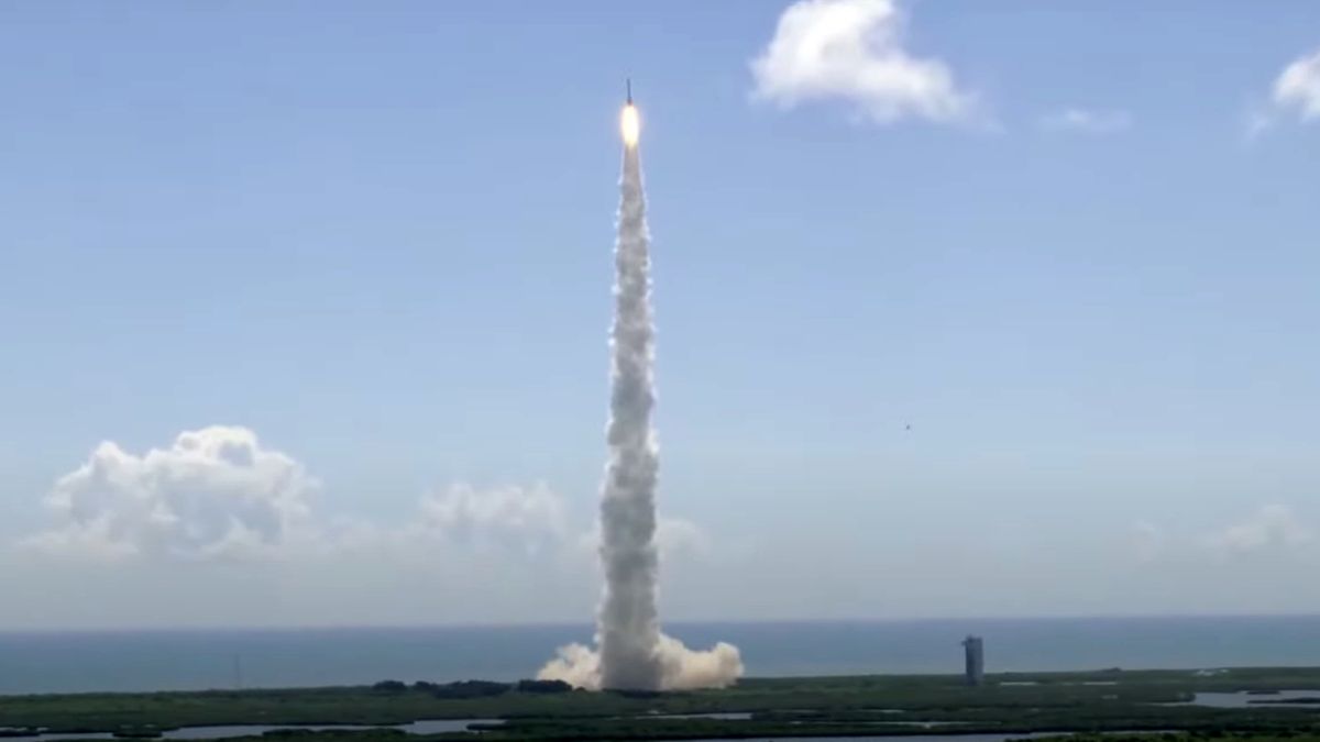 Long-distance photo of a rocket climbing into a blue sky