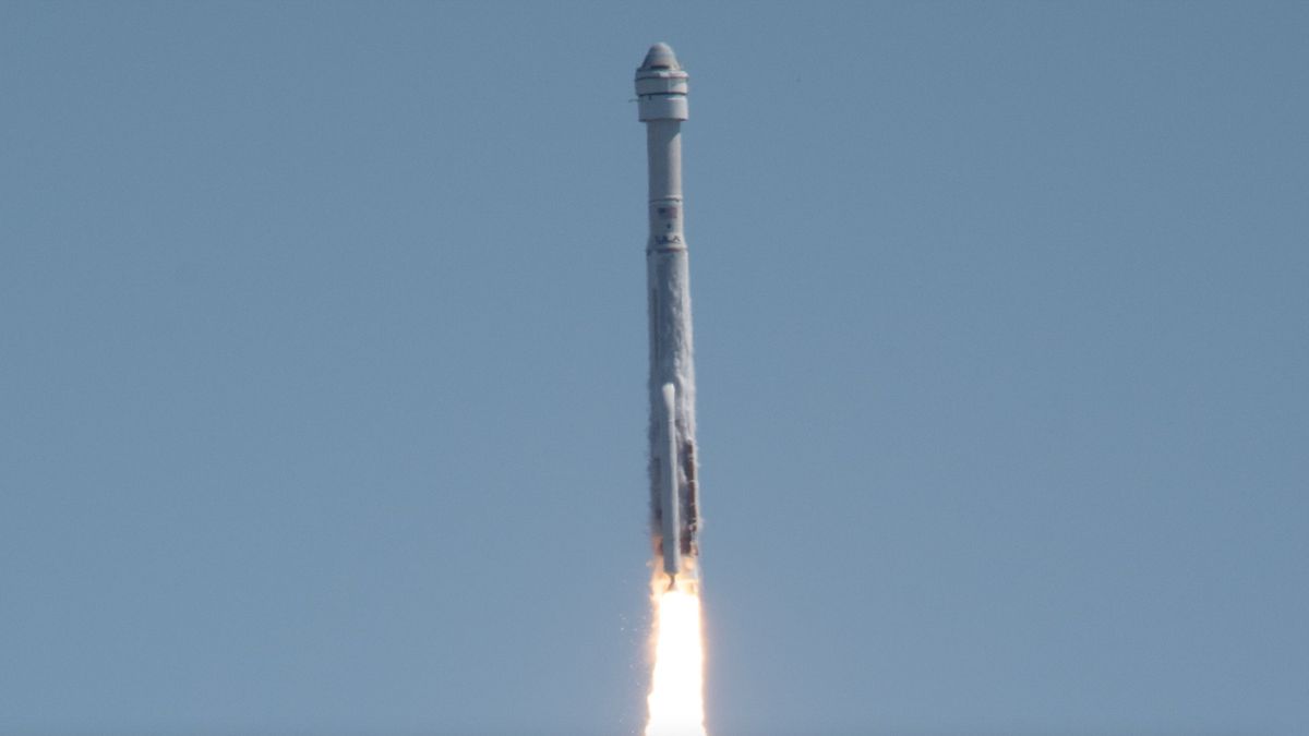 closeup view of a white rocket climbing into a blue sky